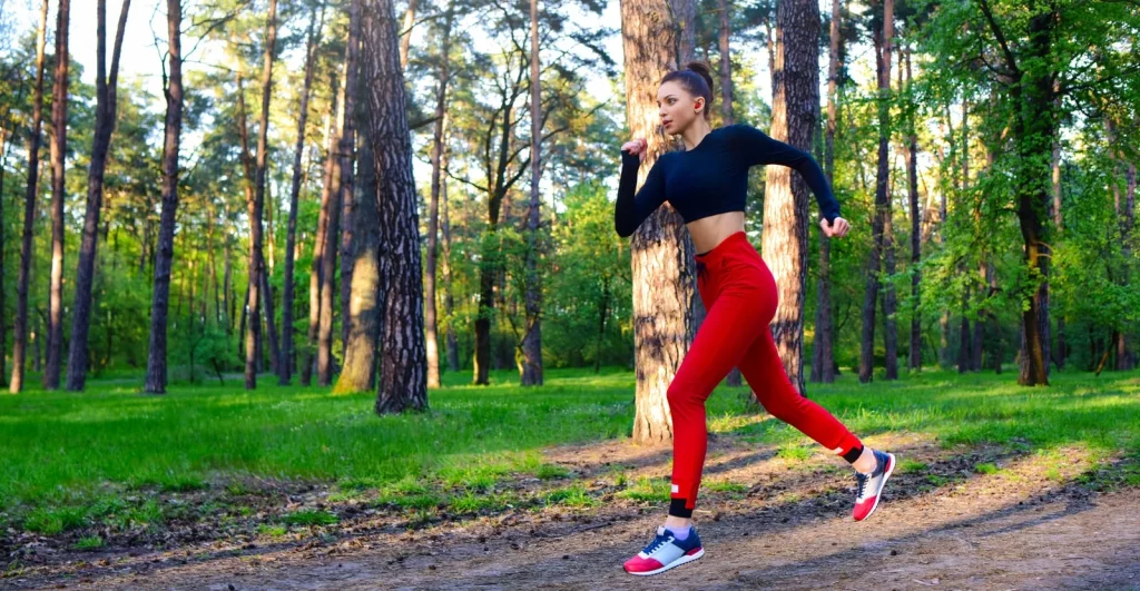 59953812\_a-young-woman-is-running-through-the-park-in-a-sports-suit