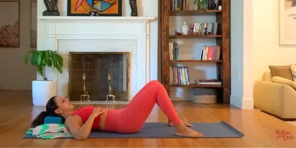 Lauren Ohayon, laying face up on a yoga mat, demonstrating correct breathing technique for pelvic floor
